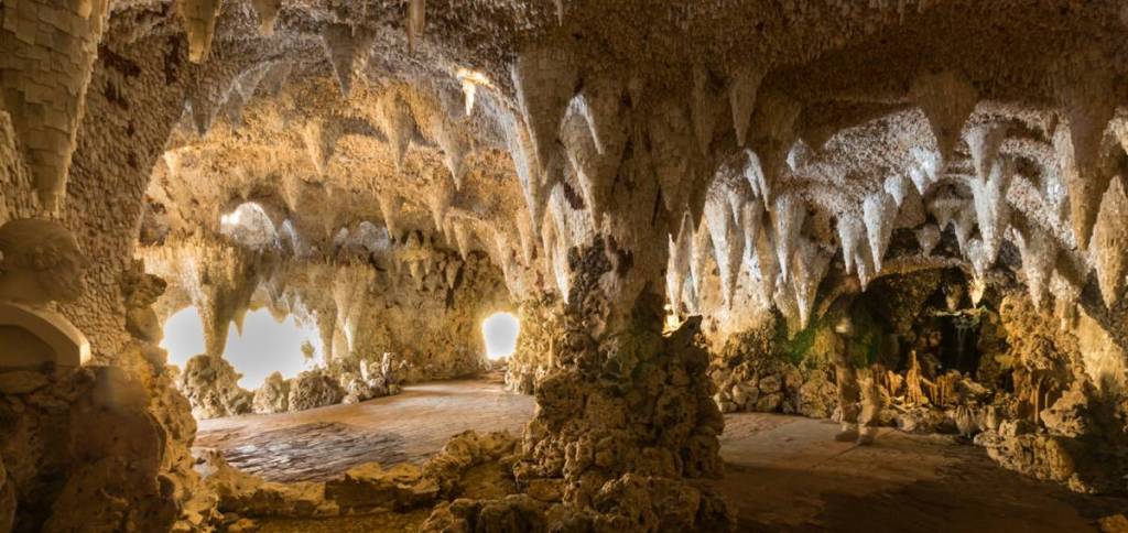 Stalaktiten und Felsen in einer künstlichen Kristallgrotte über einem See