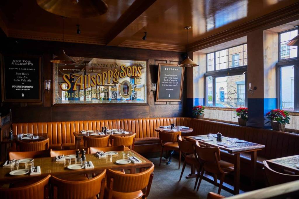 das Interieur eines Pubs in Kensington mit orangefarbenen Möbeln und einem Spiegel an der Wand