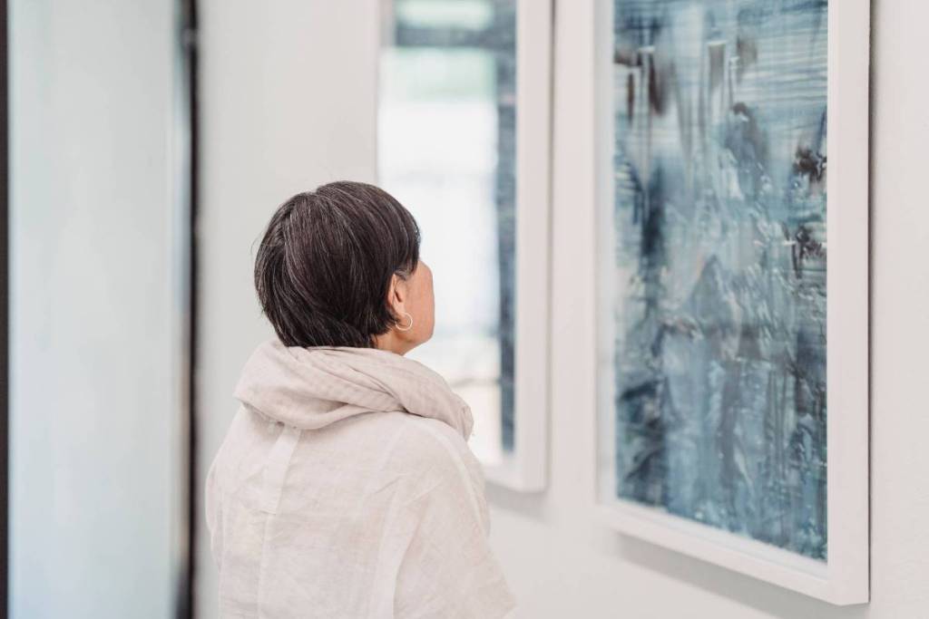 galeria de arte com uma mulher a observar um quadro