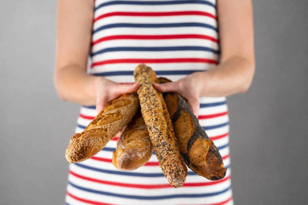 quelqu’un en chemise rayée tenant une poignée de baguettes