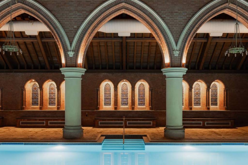 Uma piscina construída no interior de uma antiga capela, com colunas e tetos abobadados a rodear a piscina