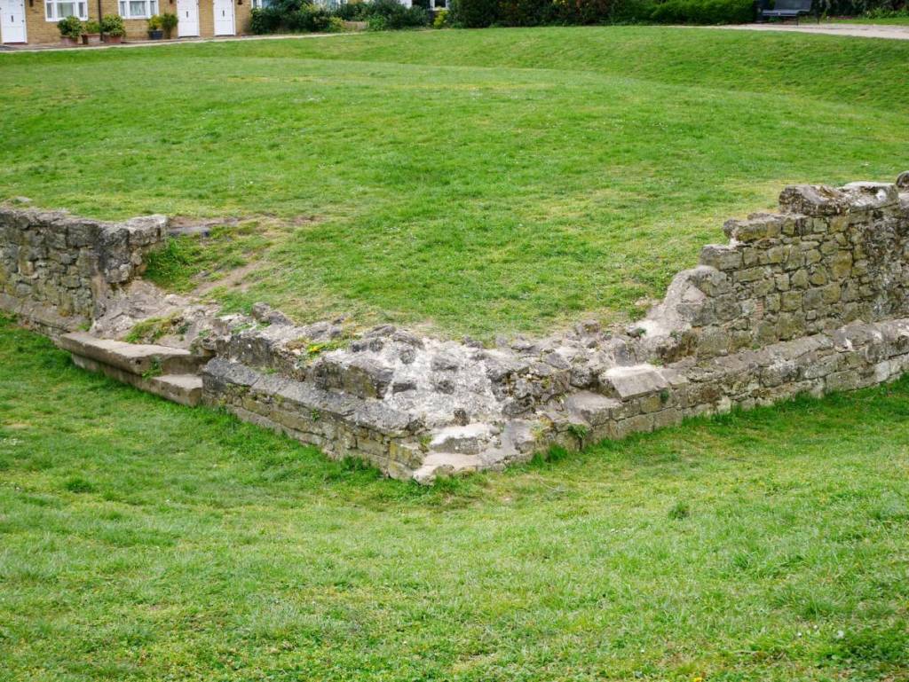 ruinas de una muralla medieval entre la hierba