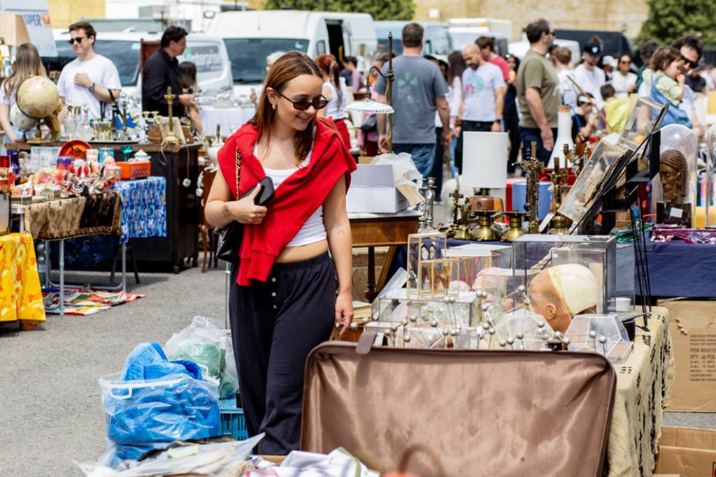 qualcuno passa davanti a un banco di merce in un mercatino delle pulci