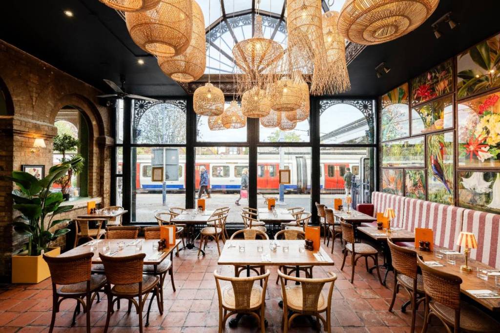 L’intérieur d’un pub dont les fenêtres donnent sur le quai d’une station de métro
