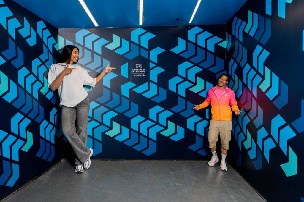 Zwei Besucher erleben eine Größenillusion im Museum of Illusions