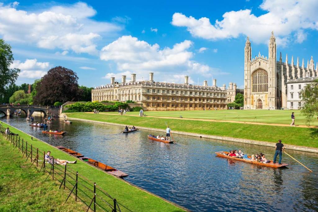 Touristen auf einer Kahnfahrt entlang des Flusses Cam in der Nähe des Kings College in der Stadt Cambridge