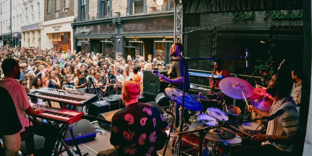 Eine Band spielt Live-Musik, während eine Gruppe von Leuten auf der Straße zuschaut