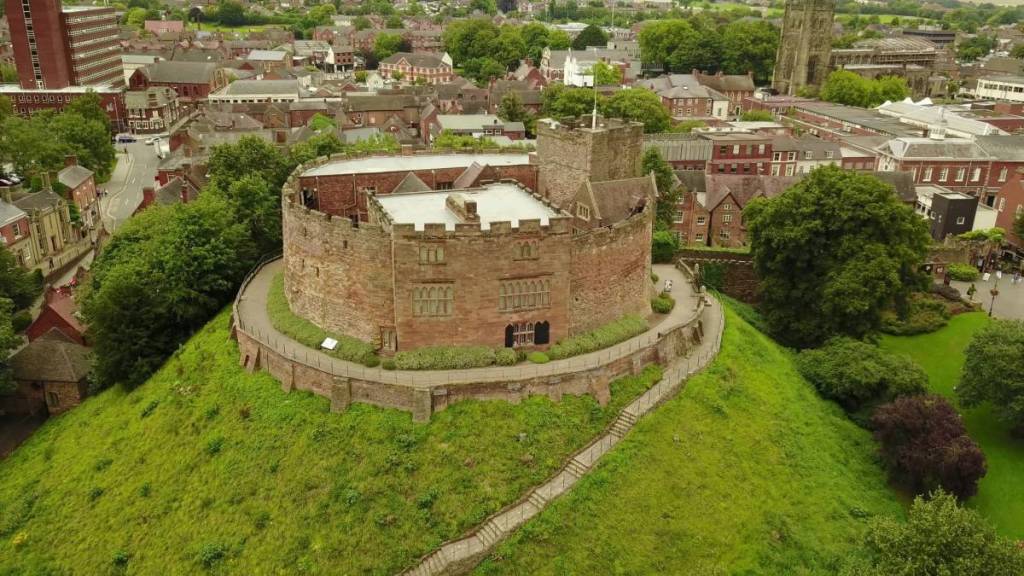 a historic castle perched on high land, surrounded by historic buildings
