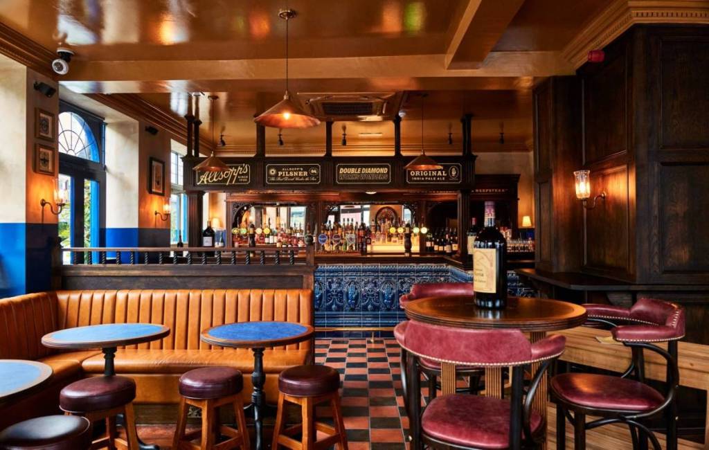 Intérieur du Blue Stoops avec son comptoir carrelé, ses sièges en cuir et son éclairage d’ambiance chaleureux.