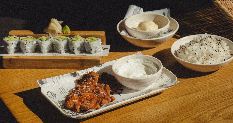 maki al cetriolo, pollo fritto, riso e gelato, il tutto servito su un tavolo di legno