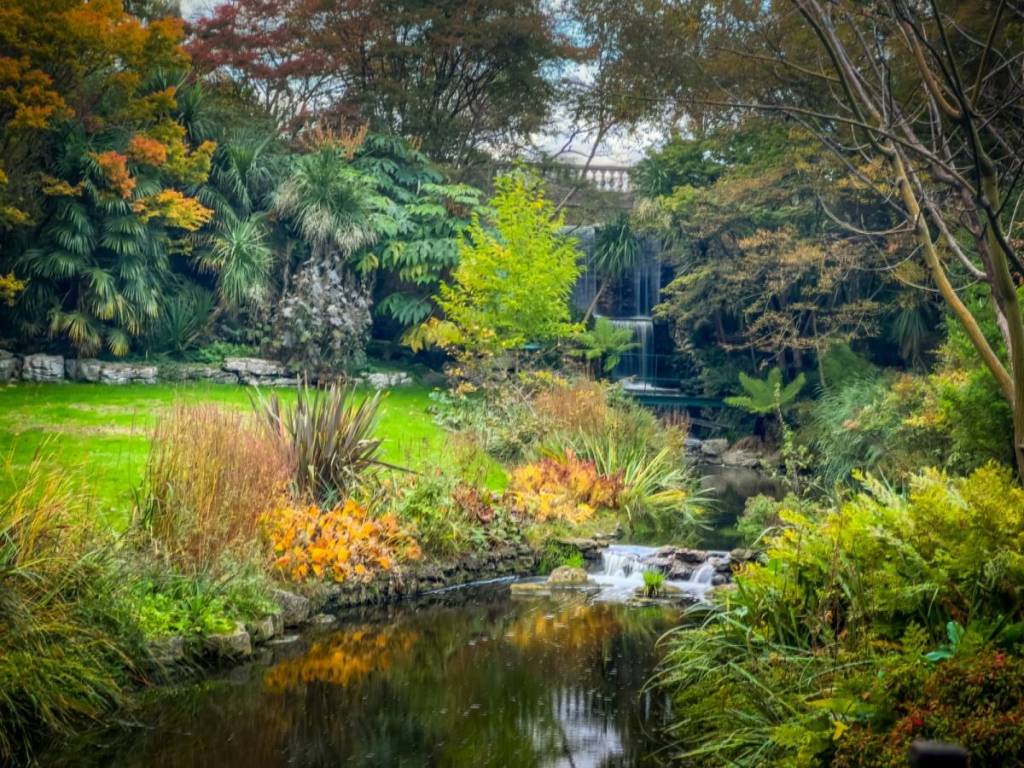 Ein Wasserfall im Hyde Park, umgeben von leuchtend grünem Laub und Pflanzen