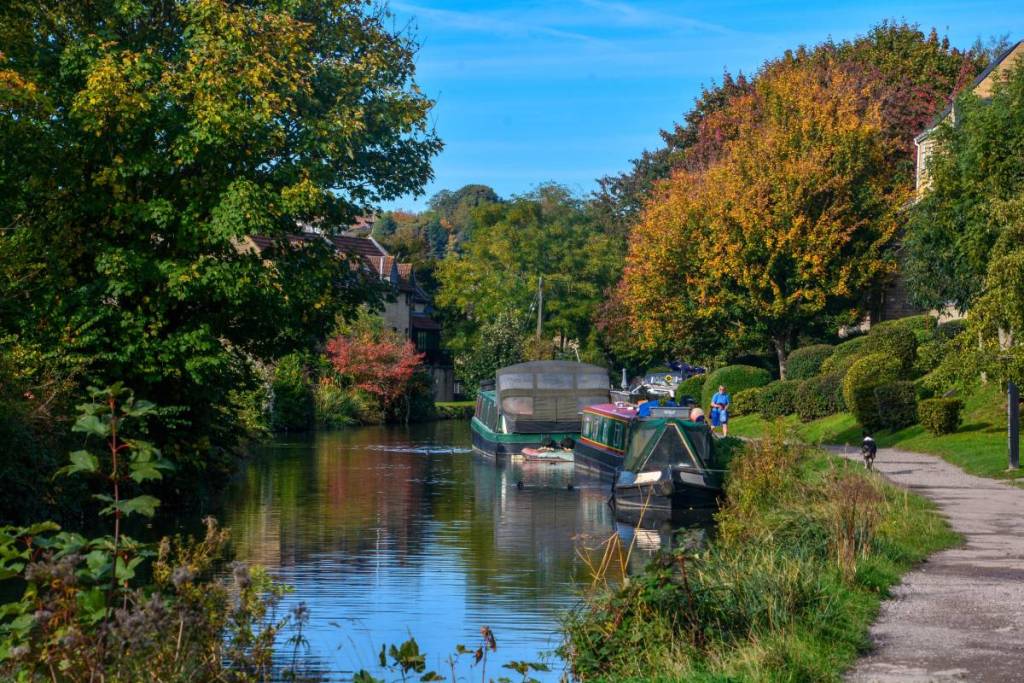 Boten op een kanaal, omringd door bomen en groen