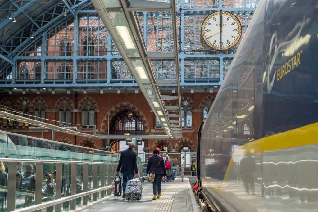 Gente caminando por el andén de la estación de St Pancras International junto a un tren Eurostar
