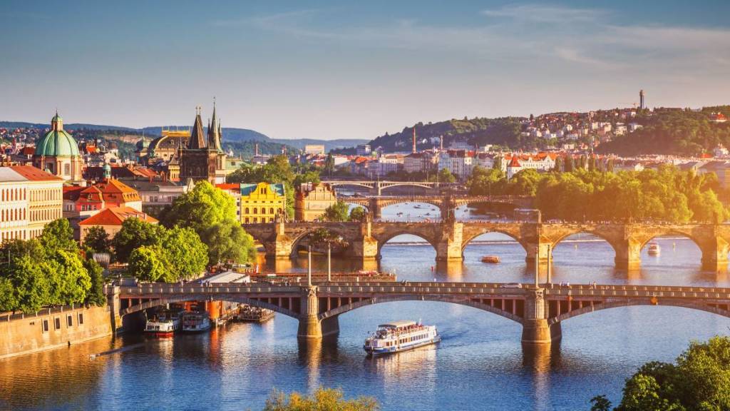 Una vista sul fiume a Praga con edifici storici e ponti in lontananza