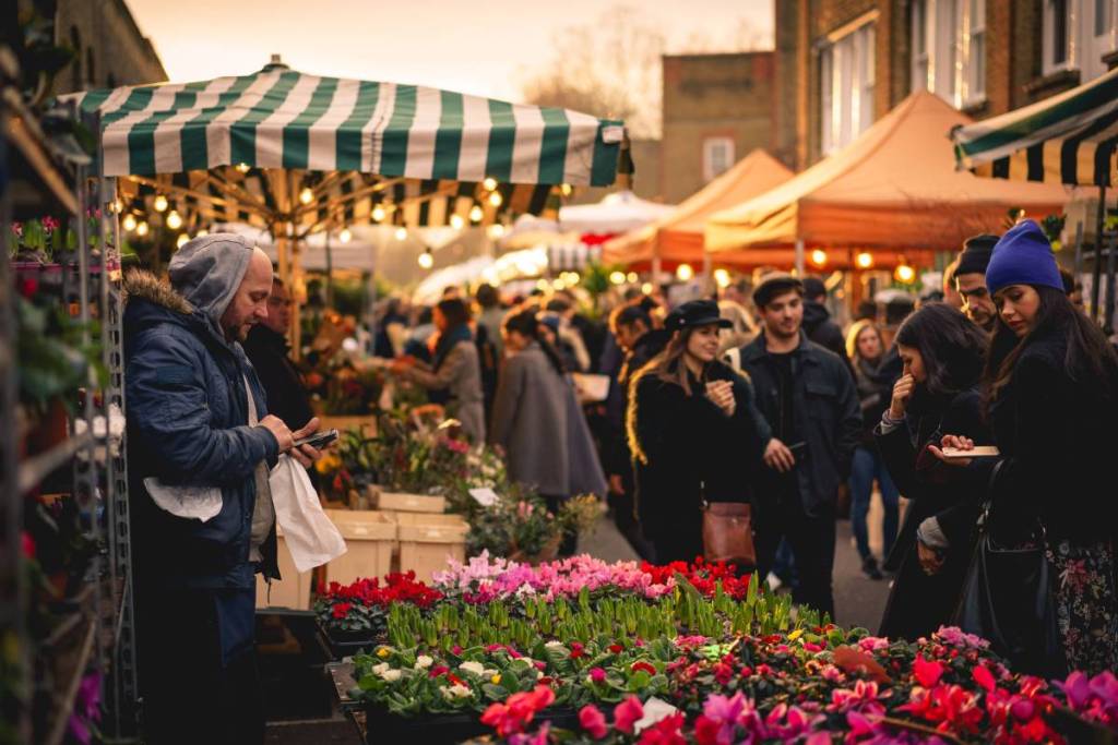 Leute, die die Columbia Road entlangschlendern und die Blumenstände durchstöbern