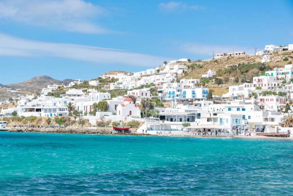 Prachtig uitzicht op de iconische witgekalkte gebouwen van Mykonos langs de levendige turquoise kust.