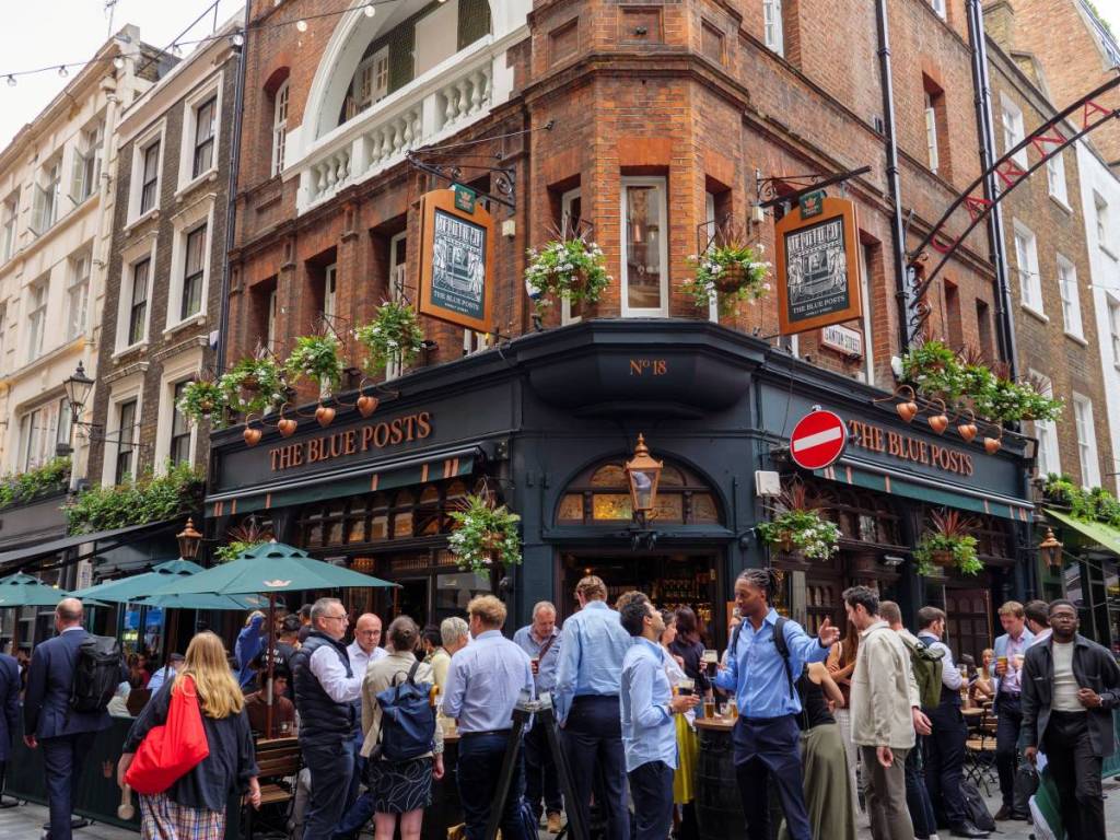Des gens se tenaient devant un pub de Soho pour discuter et boire un verre