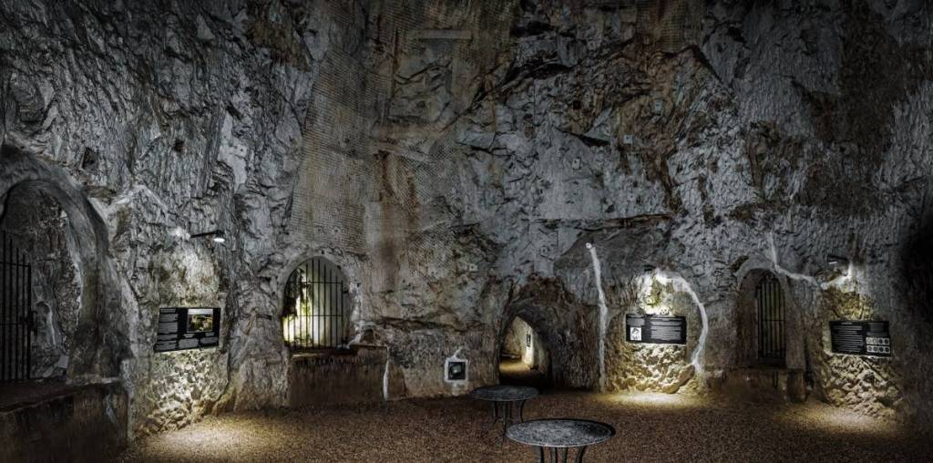 à l’intérieur de la salle de banquet des Hellfire Caves, d’où partent de nombreux tunnels, avec des panneaux explicatifs accrochés aux murs
