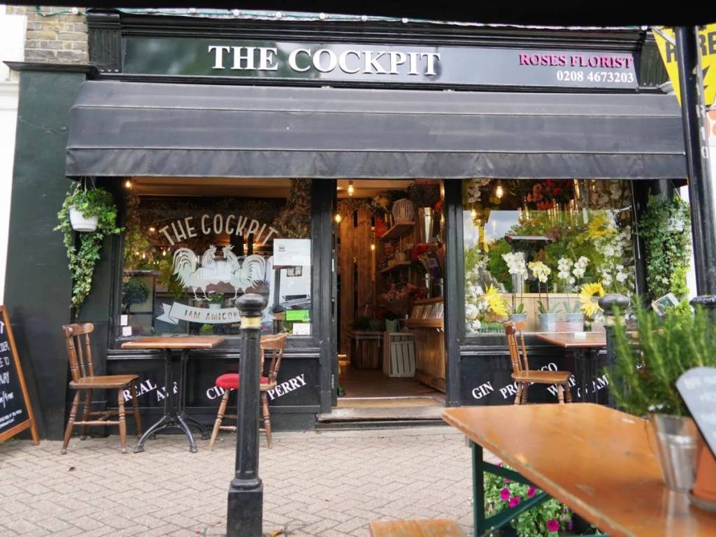 A fachada de uma florista com o pub «Cockpit» lá dentro