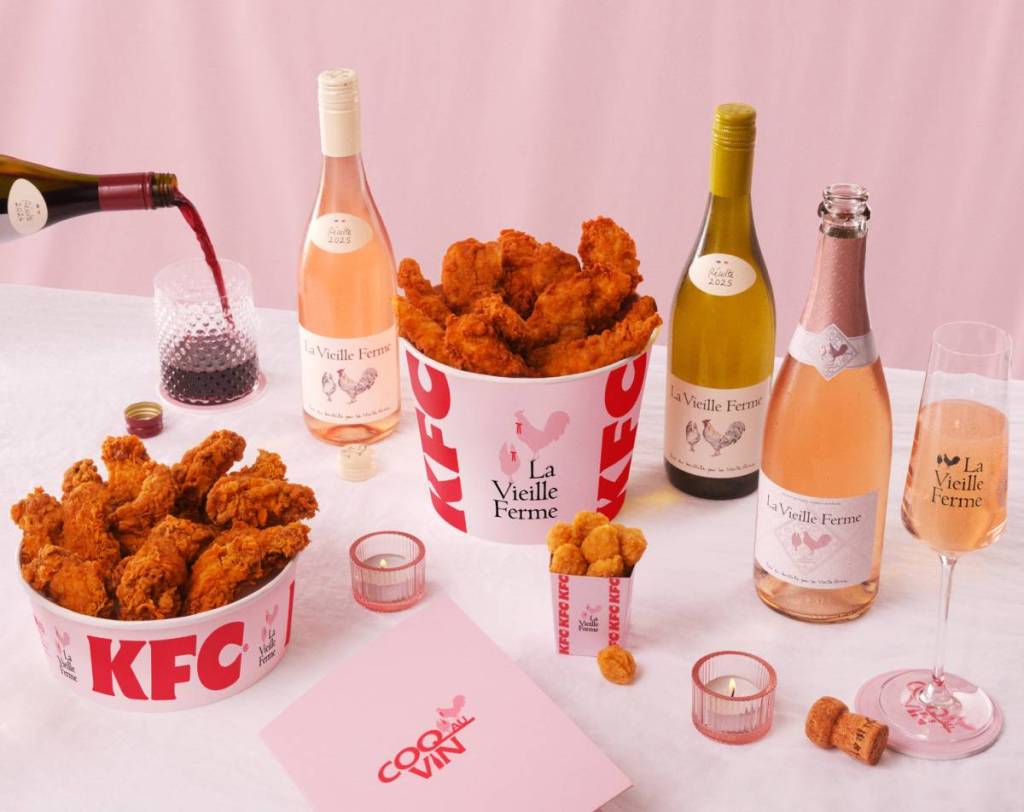 une table garnie de poulet KFC et des bouteilles de vins de La Vieille Ferme