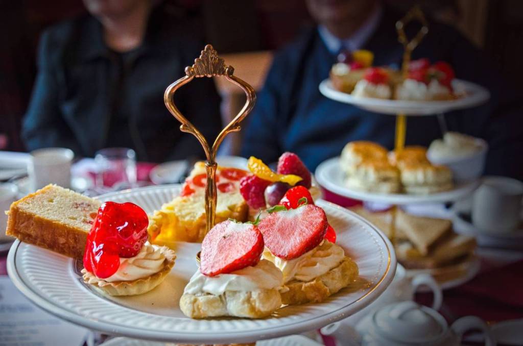 an afternoon tea plate with sweet treats topped with strawberries