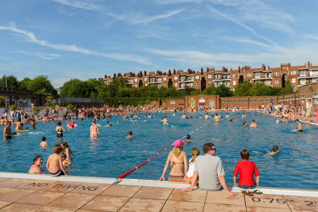 Gente nadando en un caluroso y soleado día de verano en el Parliament Hill Lido, en Hampstead