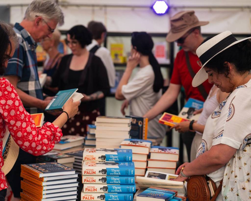 persone che sfogliano libri nella tenda-libreria del Queen’s Park Book Festival