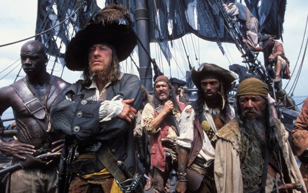 a still from Pirates of the Caribbean: The Curse of the Black Pearl showing a crew of dangerous looking pirates