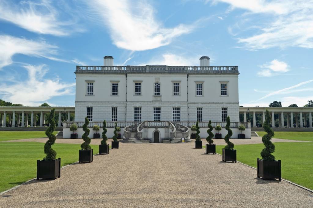 Queen's House exterior in Greenwich with a gravel path lined with swirly trees leading up to the house itself