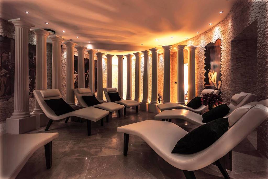 tumbonas relajantes dentro de una sala de spa de relajación de inspiración romana