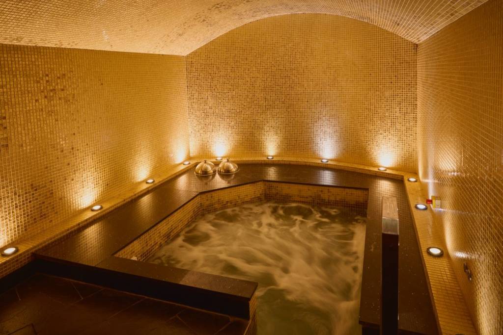 Una piscina de vitalidad dentro de un spa con luz tenue
