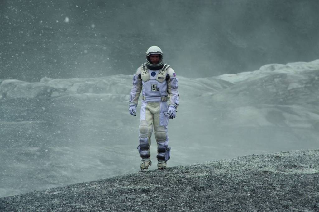 un fotogramma del film “Interstellar” che mostra un astronauta che cammina su un pianeta desolato