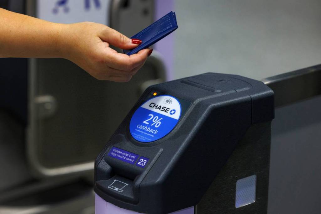 Chase logo at the barriers of the tube, a person is tapping in