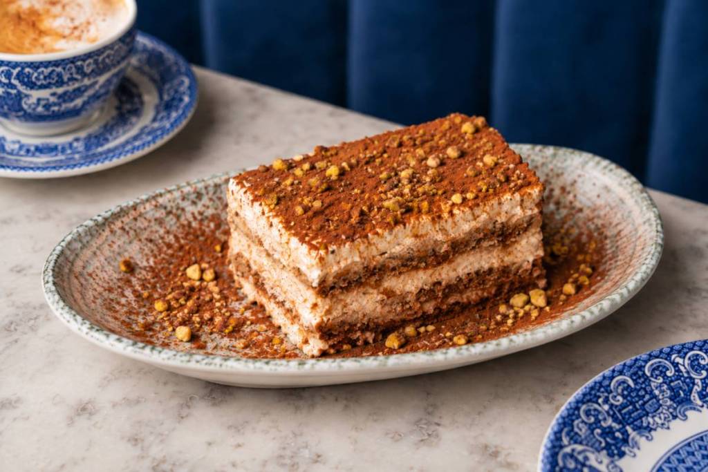 un tiramisù alla zucca speziata su un vassoio, spolverato con un po’ di spezie alla zucca in più