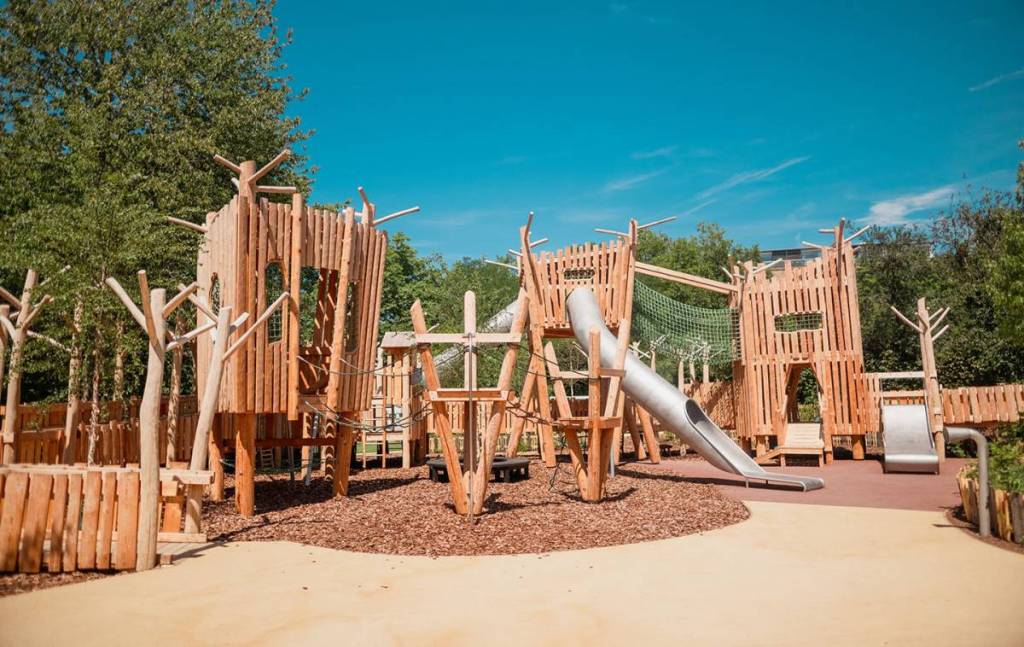 a play area at The Diana Princess of Wales Memorial Playground, with climbable sculptures, slides, and more