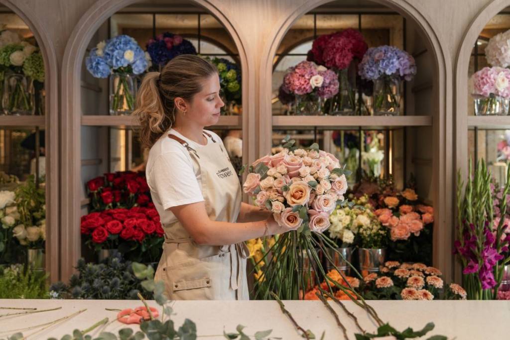 Iemand die een boeket bloemen schikt in de bloemenwinkel van Claridge’s