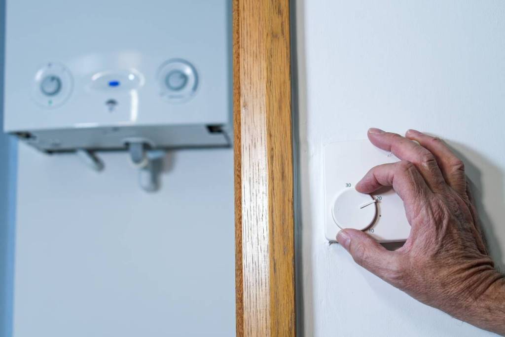 a hand moving a thermostat