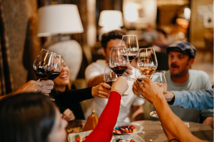 un gruppo di persone che brindano insieme con i bicchieri di vino