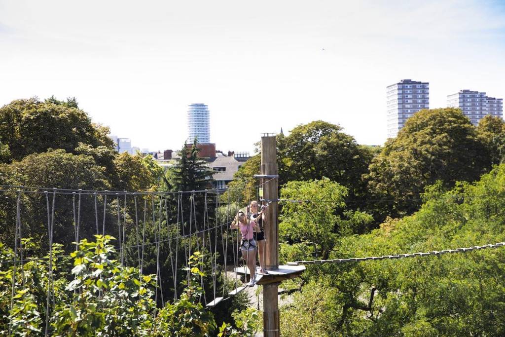 People climbing across a high rope bridge at Go Ape