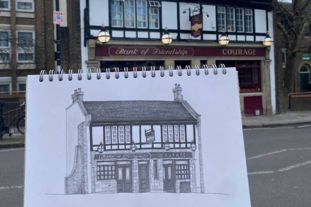Uno schizzo a matita di un pub tenuto in mano proprio davanti al pub stesso, con tanto di insegna rossa e dorata che recita “Bank of Friendship”.
