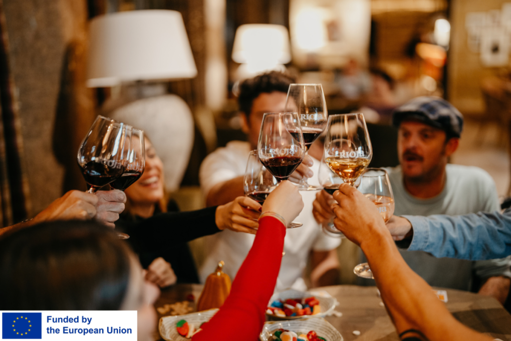 A group of people cheering with glasses of wine in a spanish tavern style setting