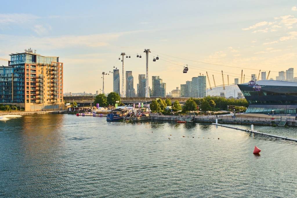 View of the London skyline at sunset, with cable cars crossing the sky