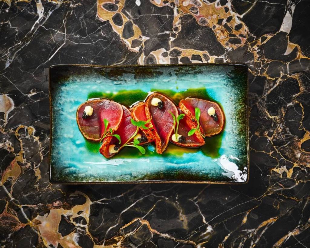 tonno scottato servito in un piatto quadrato di porcellana blu al ristorante Tattu London