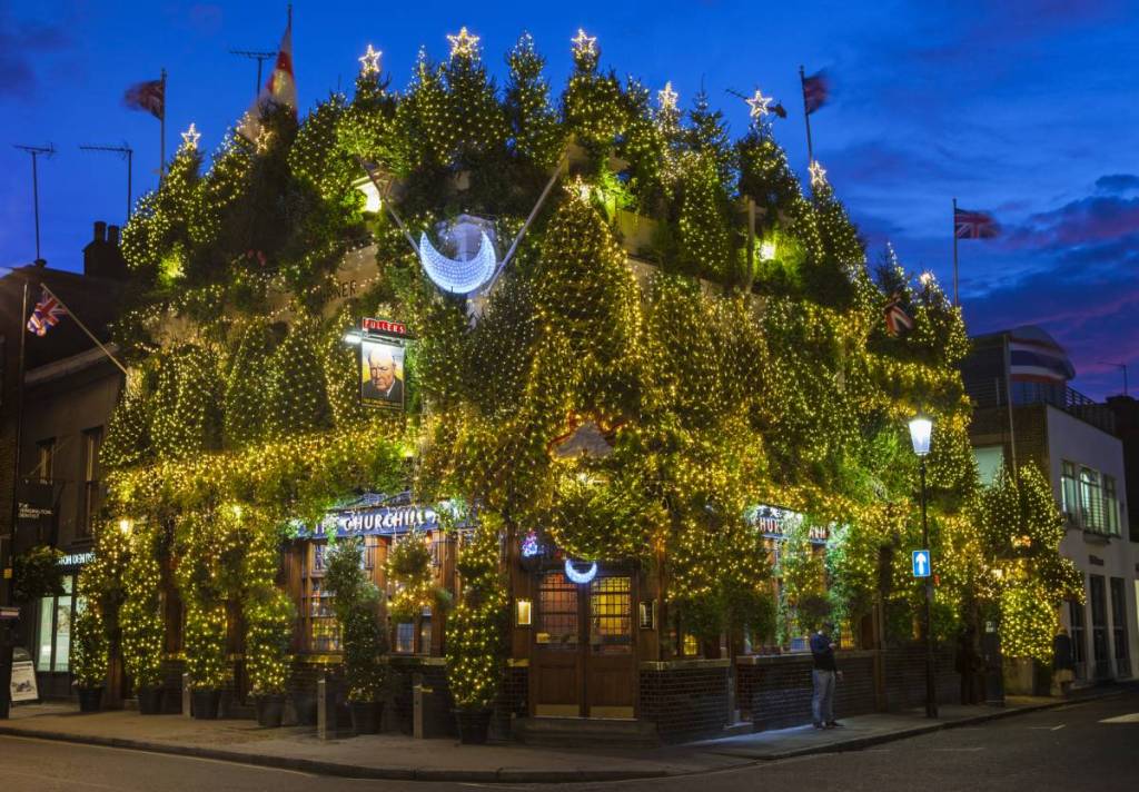 Alberi di Natale e migliaia di luci brillano sulla facciata del pub The Churchill Arms a Kensington, Londra.