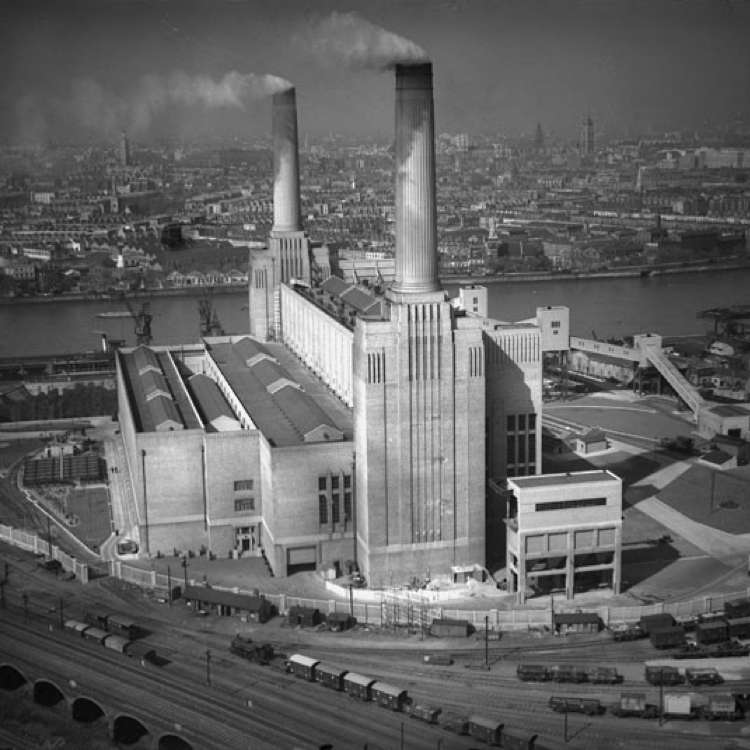 una vecchia foto in bianco e nero della Battersea Power Station quando era stata completata solo per metà, con solo 2 ciminiere invece di 4