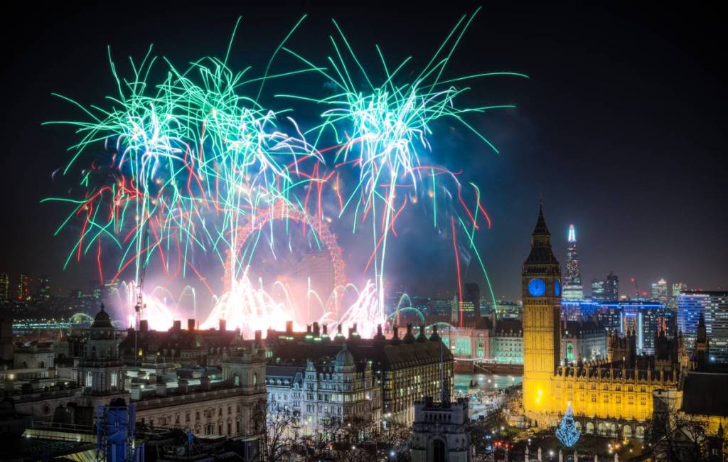 the london new years eve fireworks over london, with the elizabeth tower and the london eye visible from the london skyline