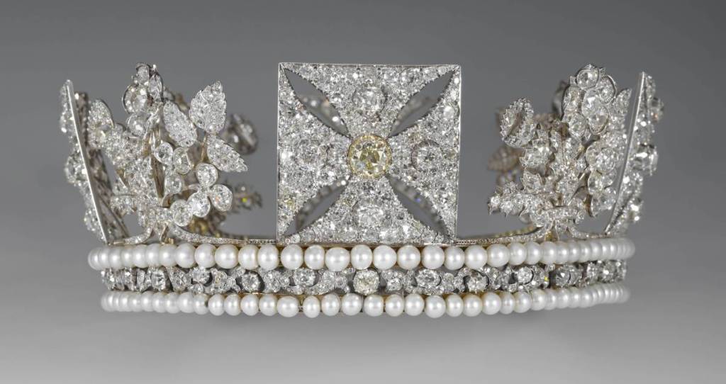 Ornate diamond tiara with pearl rows, floral clusters, and a square central panel featuring a starburst and gold accent