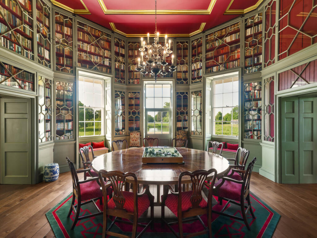 an opulent dinning room with big windows looking out to greenery
