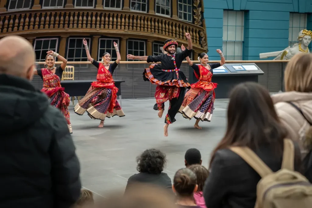 Diwali dancers in red, black and gold outfits dancing on the Ocean Map 2025 T4964-028.jpg