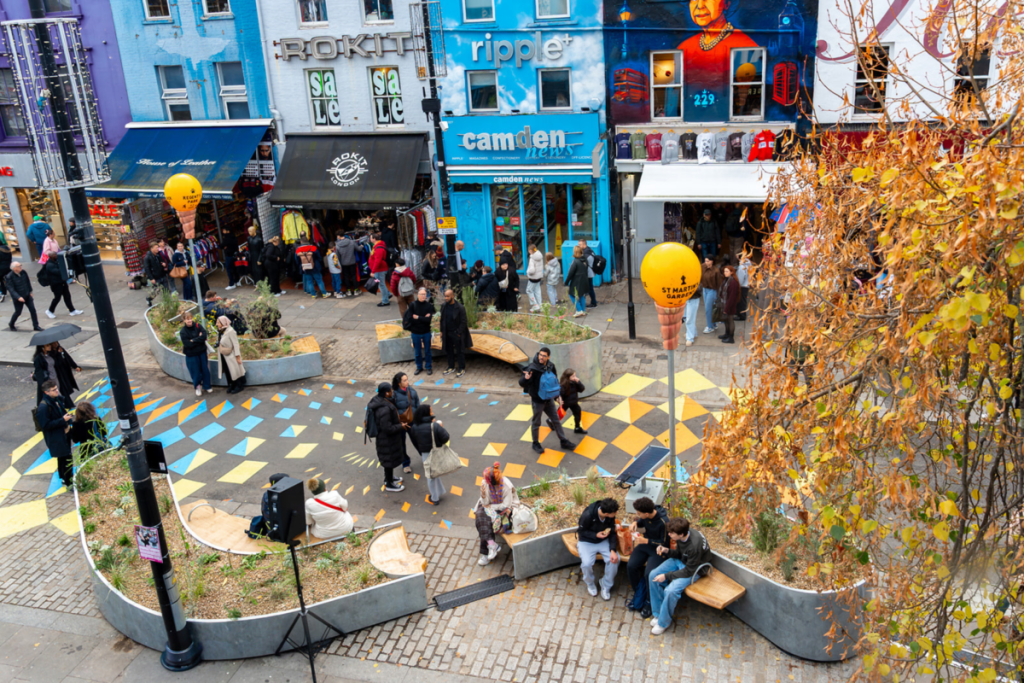 People sat and walking in a pedestrianised area of Camden High Street